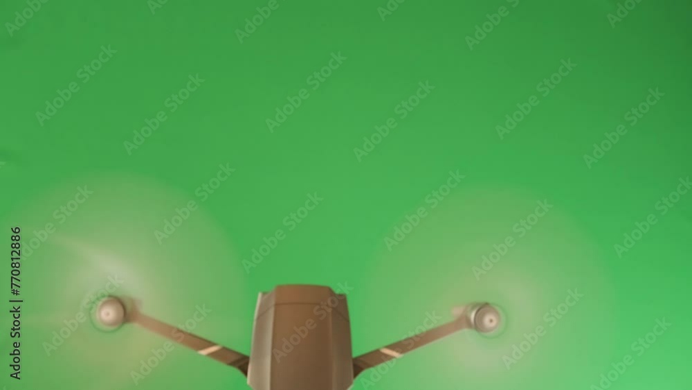 Top down view of a flying drone on green chromakey background. Copy space. Promotional sales offers. Delivery by cargo copter. Top down view of a flying drone on green chromakey background. Copy space. Promotional sales offers. Delivery by cargo copter.