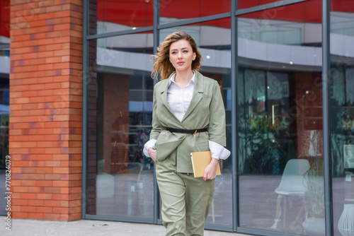 Portrait of a successful business woman in front of modern business building.Young manager poses outside. Female business leader. 