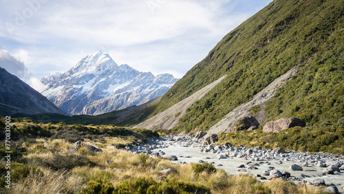 Scenic alpine valley with glacial river flowing through and prominent peak in backdrop, New Zealand
