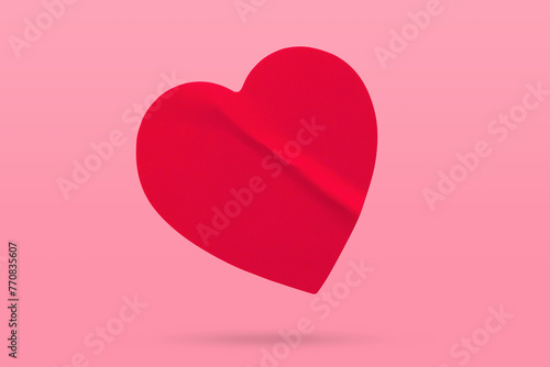 Red color heart shape sticker isolated on pink background