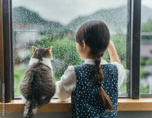 窓から雨を眺める女の子と猫のイメージ3