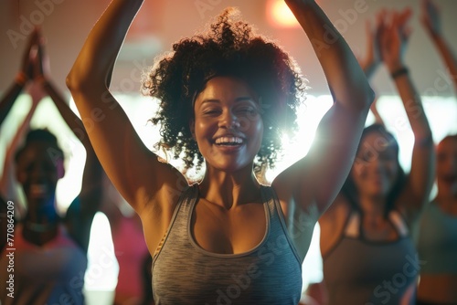 Group of women energetically practicing yoga in a gym class with upbeat music and enthusiastic participants