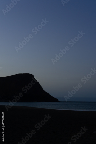 la Tejita beach sunrise in blue hour with the silhouette of the hill, the sand  and the ocean photo