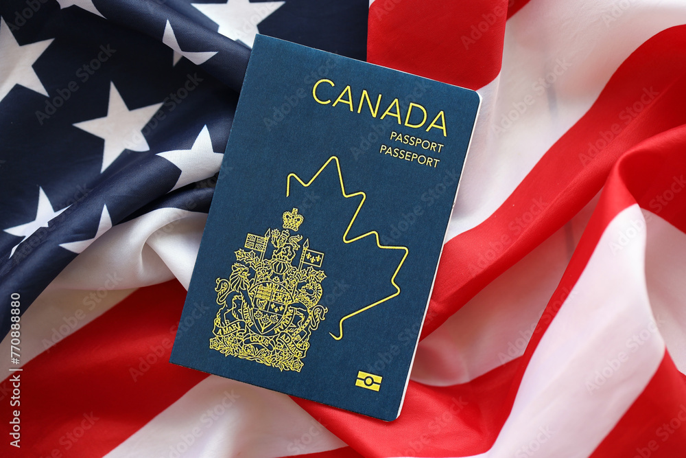 Canadian passport on United States national flag background close up. Tourism and diplomacy concept - obrazy, fototapety, plakaty 