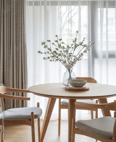 A round table with chairs on both sides, light wood color and natural fabric chair material, light gray curtains, simple home interior design style