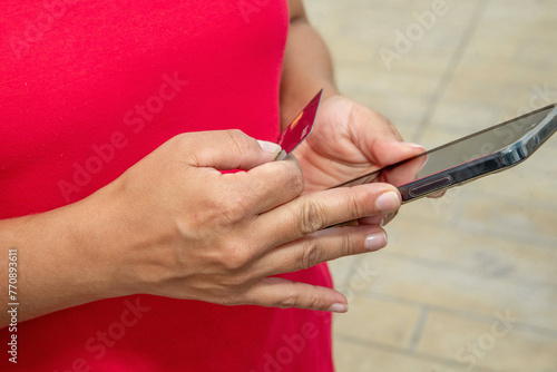 Close-up of a woman's hands exchanging a payment with a bank credit card. Detailed photo of a woman making a credit card payment.