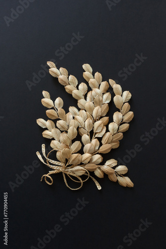 The branch with leaves is made of straw. Straw wall decoration. The products are made of straw. Straw weaving. 