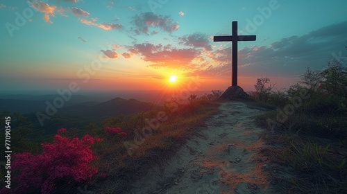  A cross atop a hill against a backdrop of sunset, surrounded by pink flowers in the foreground