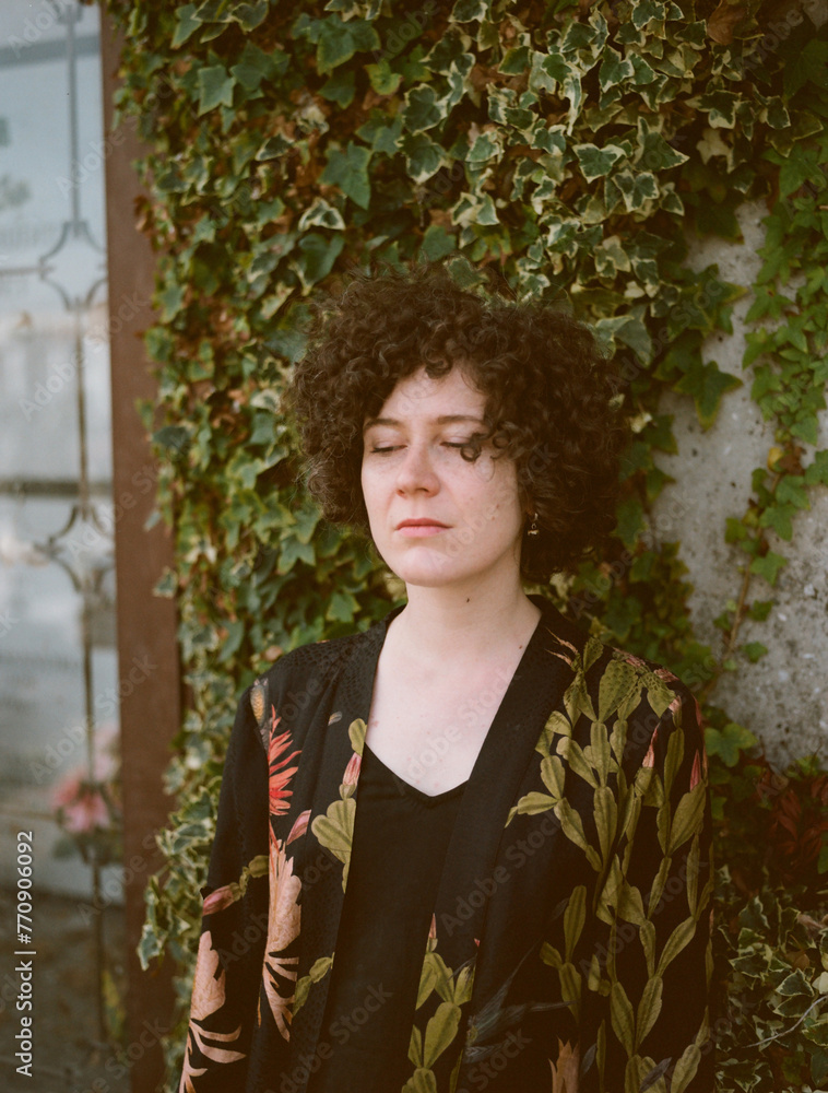 A curly woman in kimono in in a garden A curly woman in kimono in in a garden