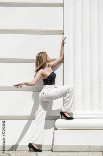 Fototapeta Naklejka Na Ścianę i Meble -  Portrait of a young beautiful blonde model in white trousers