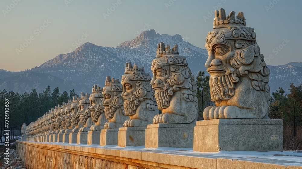   A row of statues sits atop a snow-covered ground, framed by distant mountains