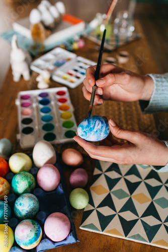 Hands of a woman painting Easter eggs photo