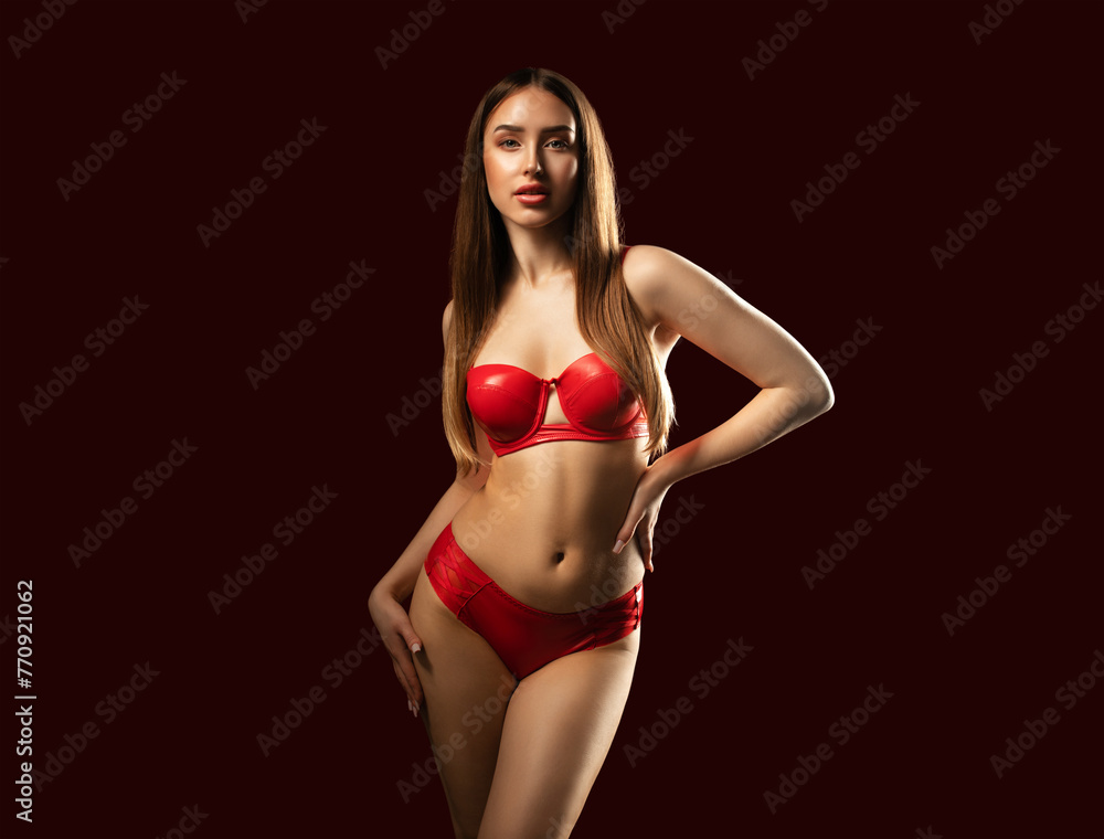 Slender sexy woman in red latex underwear on a red background.