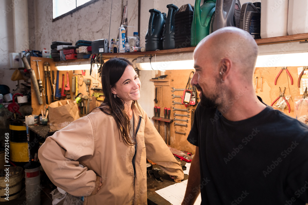 Relaxed coworkers at mechanic workshop Relaxed coworkers at mechanic workshop