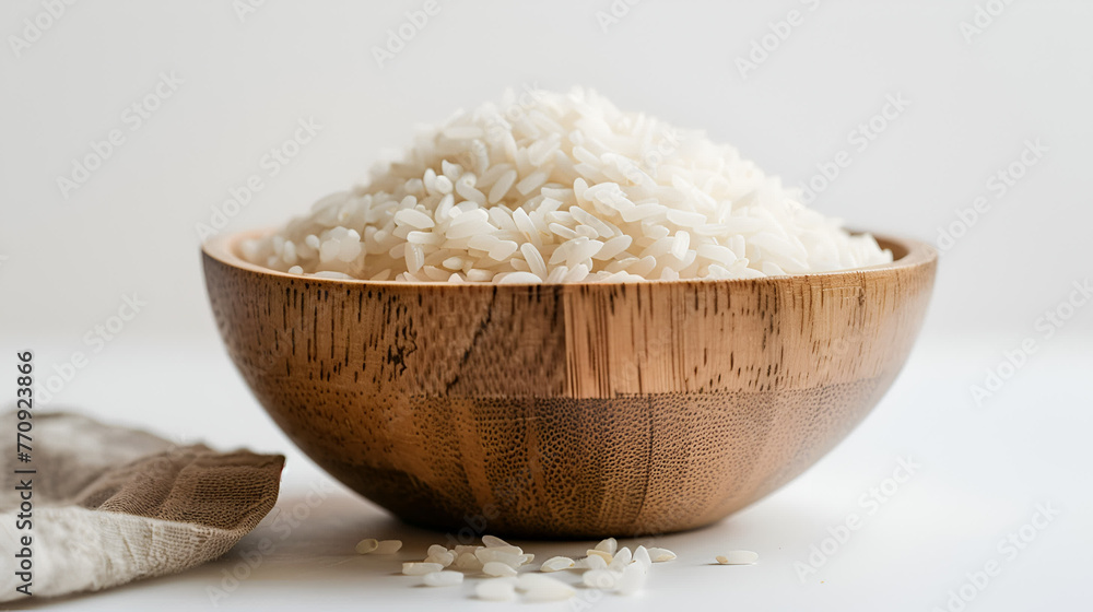 Wooden dishware with white rice, a kitchen utensil on a table Wooden dishware with white rice, a kitchen utensil on a table