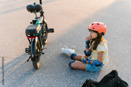 Girl in quad roller skates eating snacks during break photo