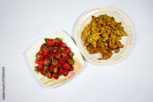 A plate of Strawberries and  Pakoras on isolated background © Muzzammil