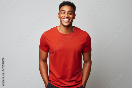 Studio portrait of smiling young black man with red t-shirt and grey background. photo