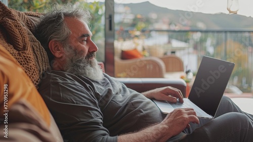 Man Sitting on Couch Using Laptop