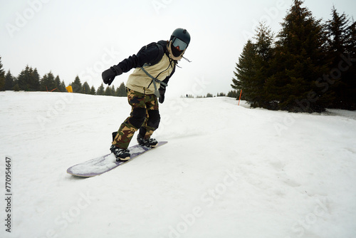 Snowboarder gliding down the slope photo