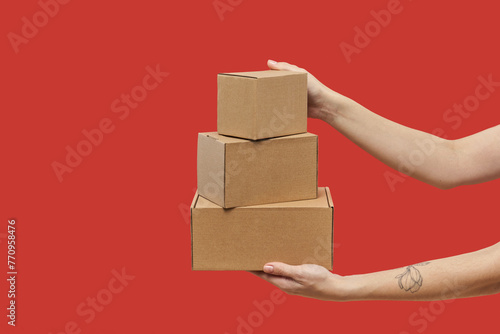 Woman's hands carrying three cardboard boxes in stack photo