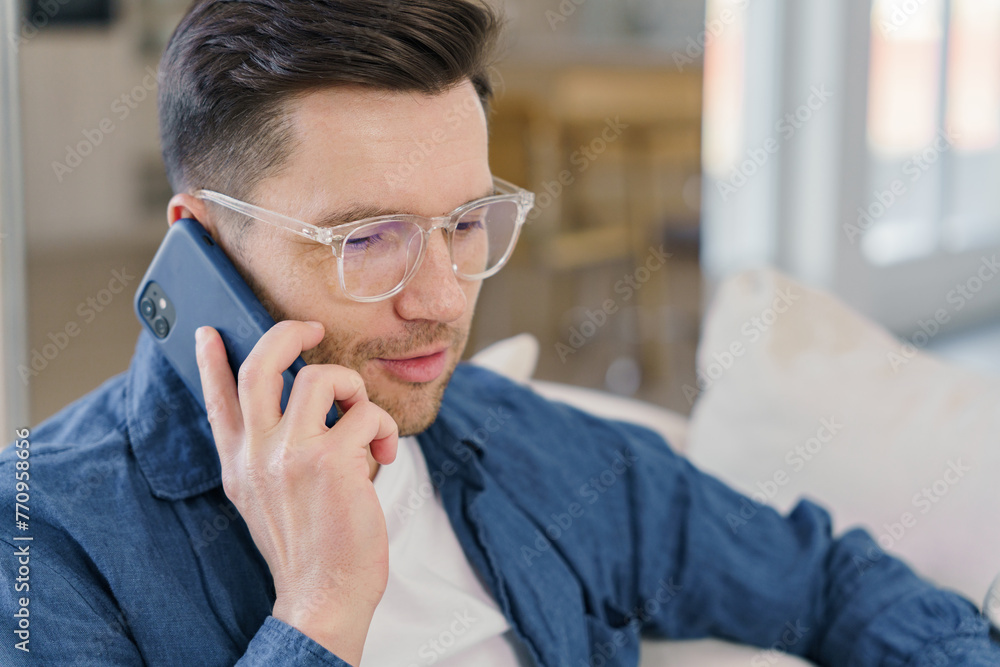 A focused man converses on a smartphone, his expression one of attentive communication. A focused man converses on a smartphone, his expression one of attentive communication.