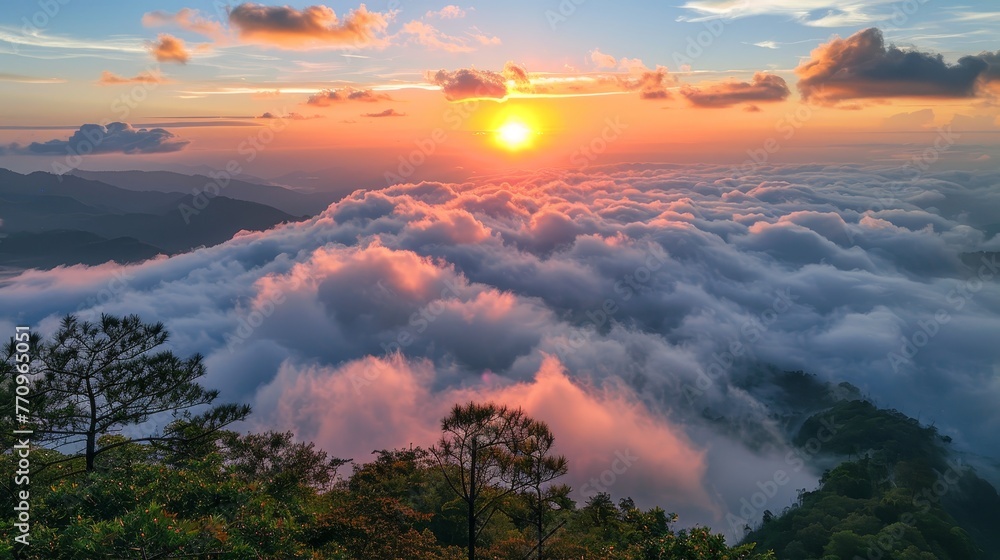 The sky is filled with clouds and the sun is setting. The clouds are white and fluffy, and the sun is orange and low in the sky. The scene is peaceful and serene, with the clouds
