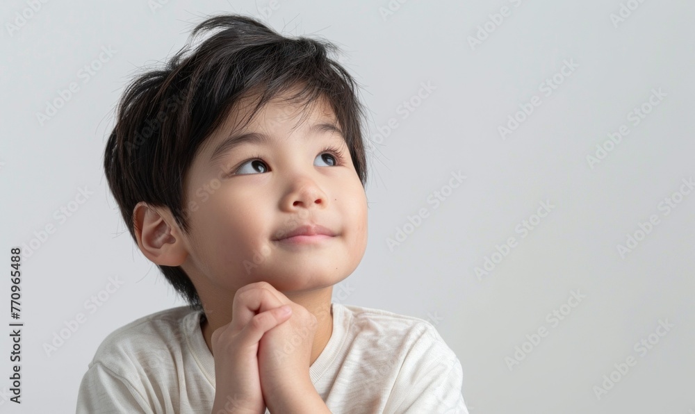 A cheerful Chinese boy gazes upward with wonder, portraying youthful innocence against a clean white backdrop A cheerful Chinese boy gazes upward with wonder, portraying youthful innocence against a clean white backdrop
