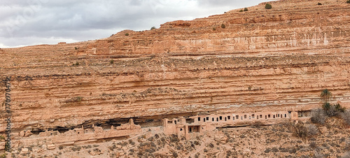 The balconies of Ghoufi, ancient Berber village, with stone and clay houses, carved into waterfalls in the rock, and the river which waters the oasis of palm trees and fruit trees. Batna. Algeria photo