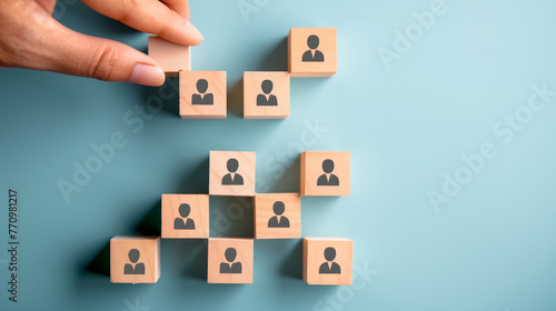 Title: "Team Building Pyramid" Art Description: A symbolic representation of team building and employee development, depicted through the placement of wooden blocks with human icons in the shape of a 