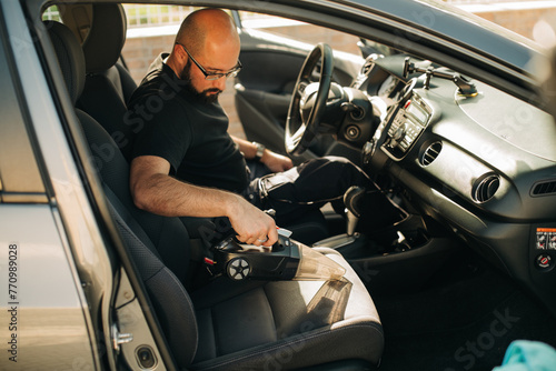 Man cleaning interior of a car photo