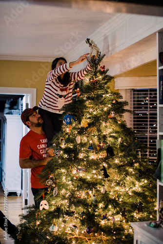 child decorating christmas tree