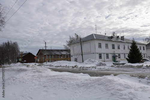 Old hobbled houses, peeling facades. Skewed lampposts, roads with dirty snow. Cloudy skies. A provincial town in the north of Russia.