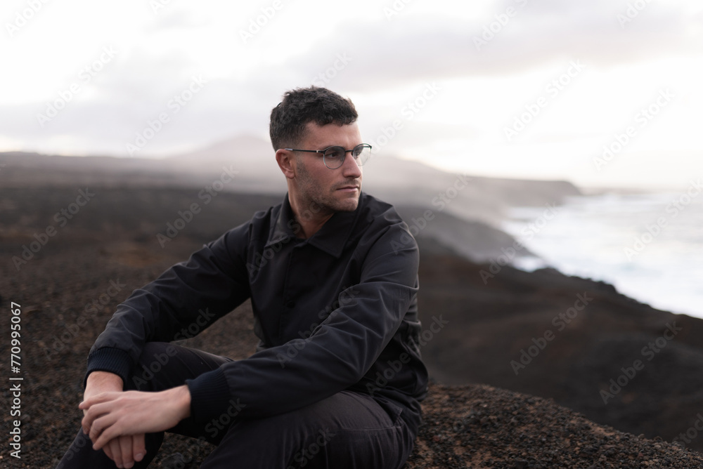 A person is relaxing on the edge of a cliff at top of a mountain