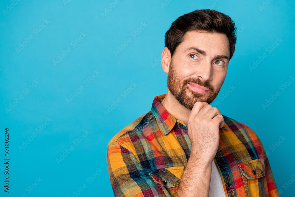 Portrait of minded intelligent guy with stubble wear plaid shirt look at interesting offer empty space isolated on blue color background Portrait of minded intelligent guy with stubble wear plaid shirt look at interesting offer empty space isolated on blue color background