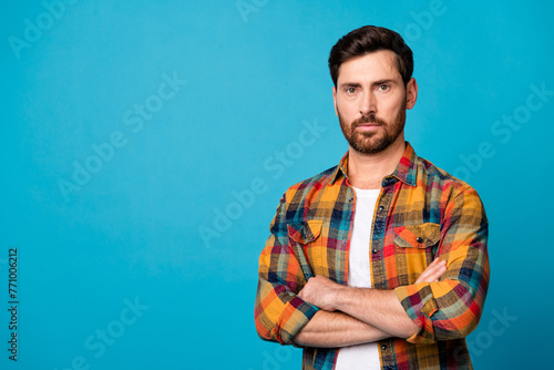 Photo portrait of nice young guy strict pose folded hands confident dressed stylish checkered garment isolated on blue color background
