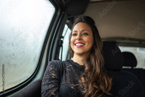 portrait of elegant young woman traveling by car on a rainy day photo