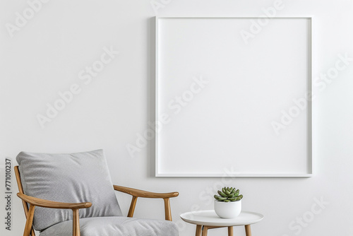 Modern and simple display featuring white empty frame on wall, stylish chair, and small table with succulent.