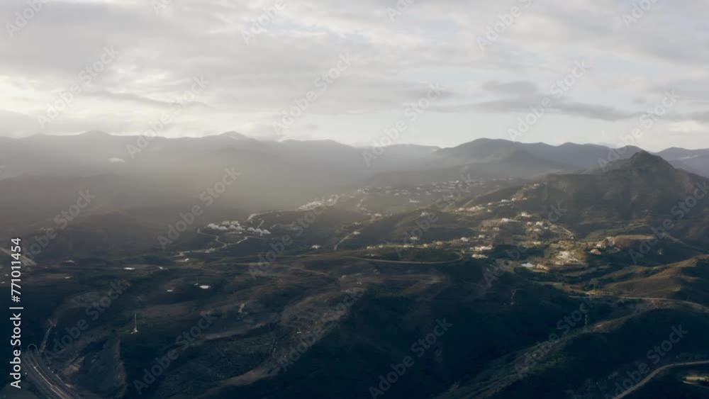 Drone showing breathtaking view of mountain landscape under cloudy foggy sky with light sunlight Drone showing breathtaking view of mountain landscape under cloudy foggy sky with light sunlight