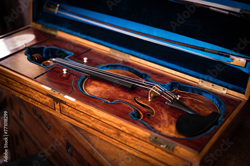 Detail of a historic high-end artisan violin in its case, a luxury collector's item from the 18th century. Made by a luthier with high quality wood
