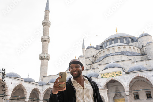 Man After Hair Transplantation Using Phone At Blue Mosque photo