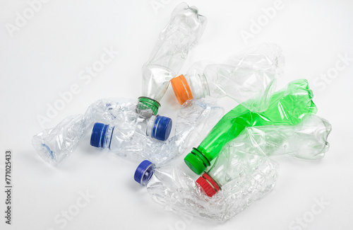 Pile of crushed used plastic bottles on white background.