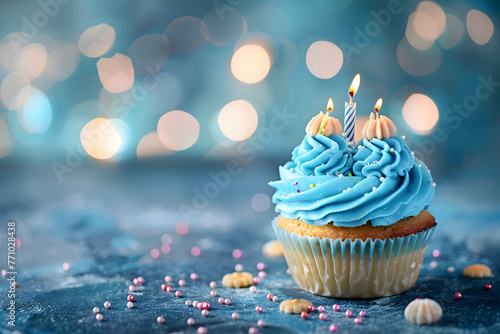 Birthday cupcake with candles on a light background. Happy Birthday concept, copy space for text, banner design, blue color scheme, soft lighting. © jex