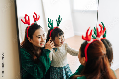 Happy family in Christmas reindeer horns having fun on living photo