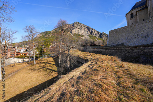 Moat of the walled city of Briançon built by Vauban in the French Alps - Citadel with colorful houses on top of a rocky spur in a mountainous valley in France