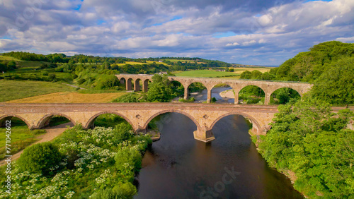 AERIAL: Picturesque Scottish landscape and two old stone bridges crossing river