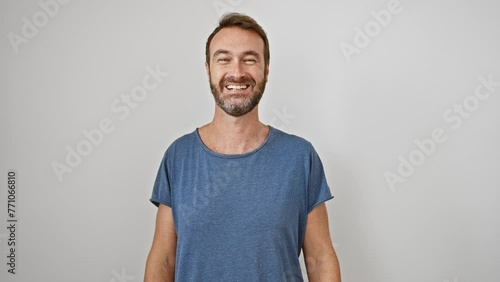 Cheery middle-aged hispanic man happily grinning, confidently looking positive with a toothy smile on a white isolated background. handsome guy enjoying success, delightedly beaming. photo