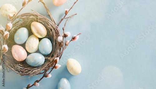 easter holiday celebration banner greeting card with pastel painted eggs in bird nest on bright blue backround tabel texture top view flat lay with copy space photo