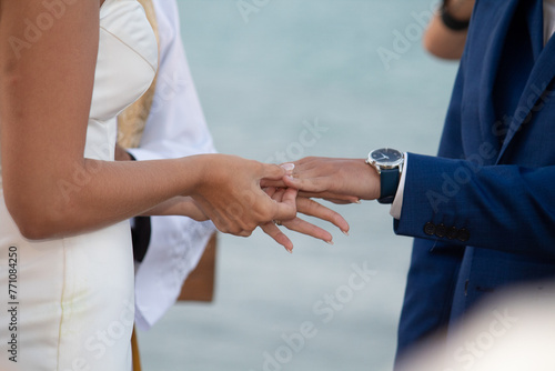 people shaking hands, exchange of rings, wedding, close-up of the groom holding a ring, close-up of a man holding a ring, moment of the ring, wedding ceremony, close-up of hands, groom and bride

