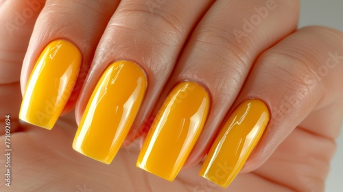 Stylish woman s hand with vibrant yellow nail polish on well manicured nails in close up view photo